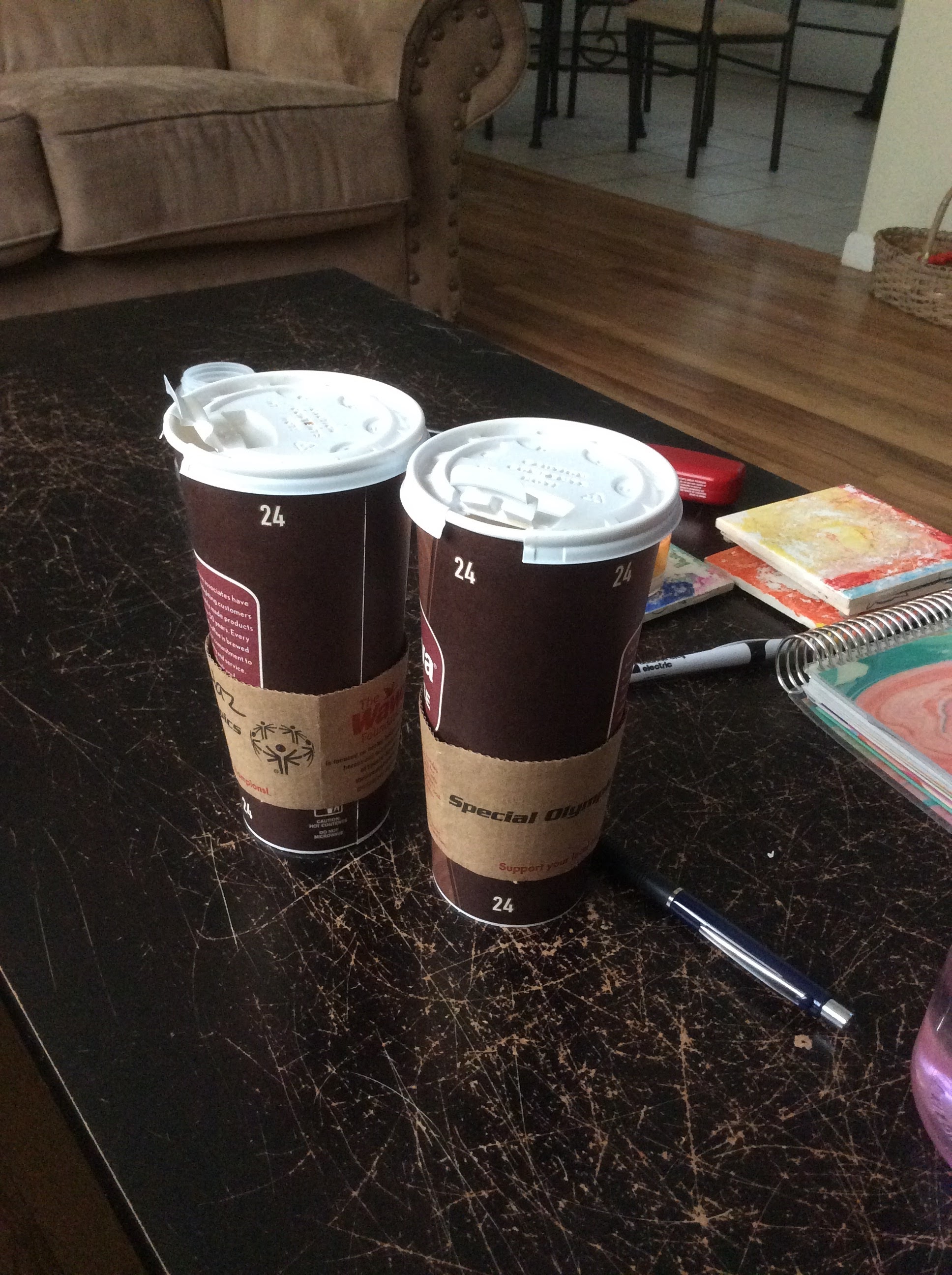two cups of coffee and note pads on table