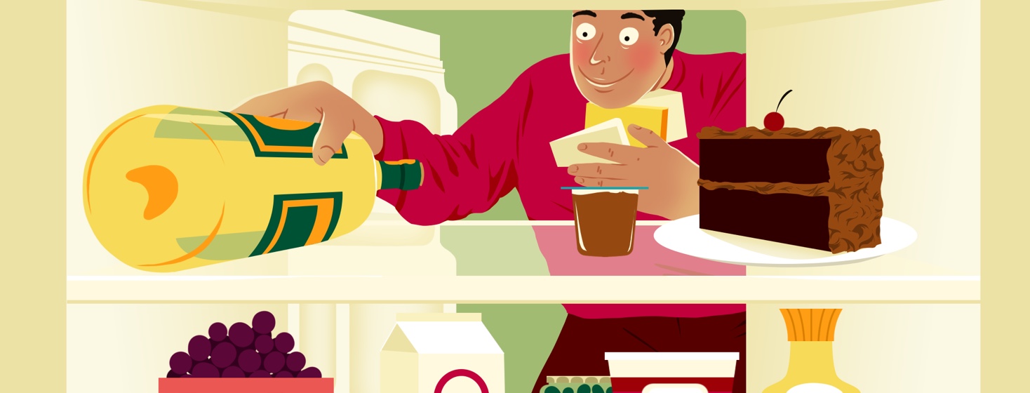 A man hungrily looks into a fridge. He is holding three chunks of cheese under his chin and is reaching past chocolate pudding and a slice of chocolate cake to grab a bottle of white wine.