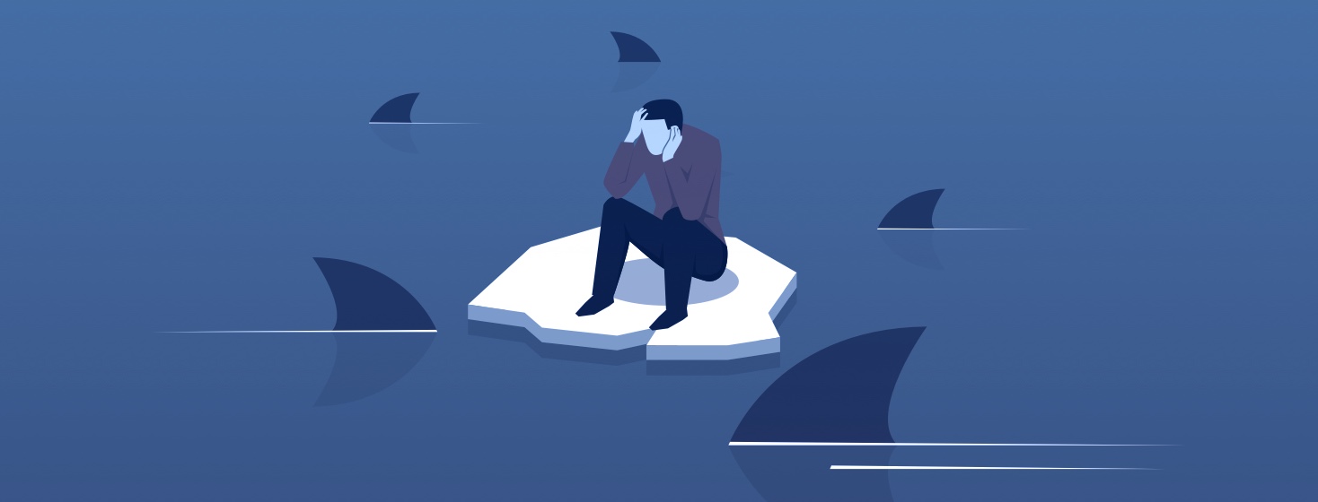 person sitting on a melting piece of ice in the ocean surrounded by sharks