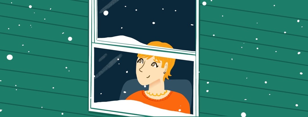 A woman longingly looks out of her window as the snow falls.
