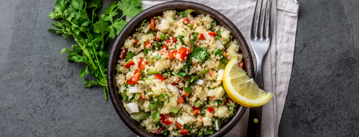 quinoa salad in clay bowl, slate gray background